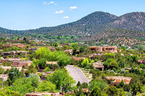 Cityscape of Santa Fe, New Mexico city by Sangre de Cristo mountains and road street by adobe traditional houses luxury wealthy community