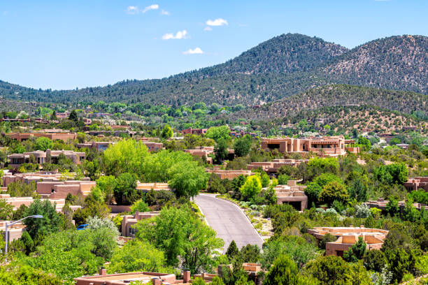 Cityscape of Santa Fe, New Mexico city by Sangre de Cristo mountains and road street by adobe traditional houses luxury wealthy community stock photo