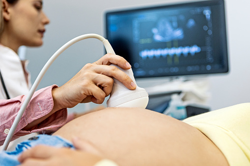 Young female doctor performing ultrasound on a pregnant woman