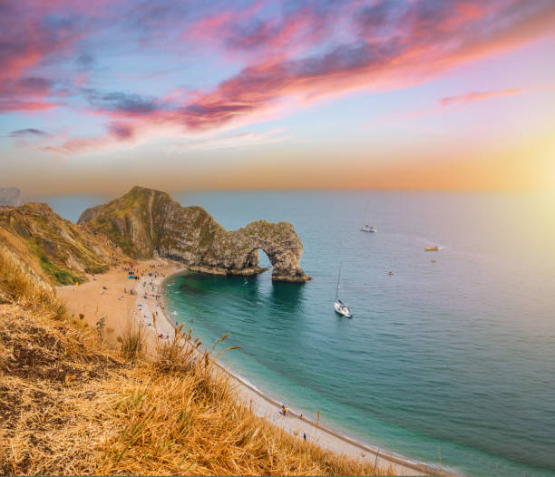 A wide angle view looking west over Durdle Door Beach as dramatic cloud starts to form after sunset.
