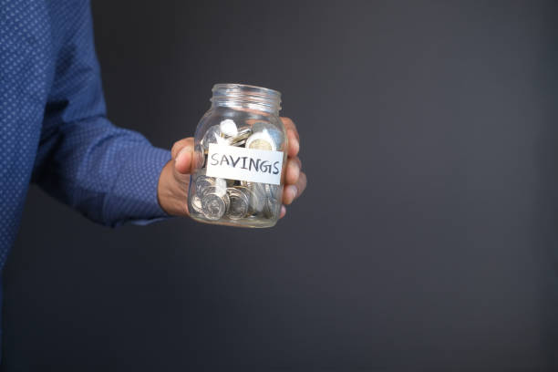 istock young man saving coins in a jar white sited 1449421200