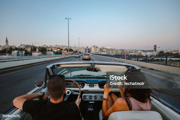 People Riding In Town In A Vintage Car Stock Photo - Download Image Now - Driving, Sports Car, Couple - Relationship