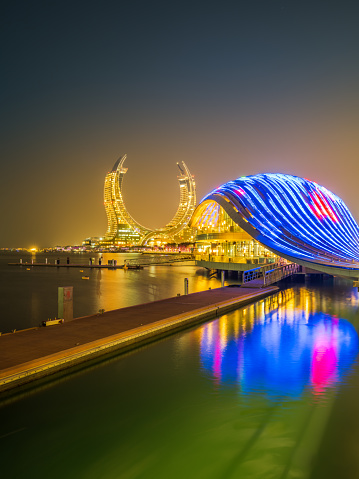 New modern buildings on the beachfront lit up at night in Lusail, Doha, Qatar