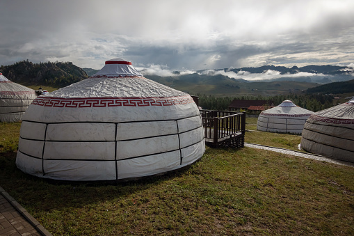 Yurt camp on a beautiful sunny day in Mongolia. Ger campsite in rural country, nature in the background.