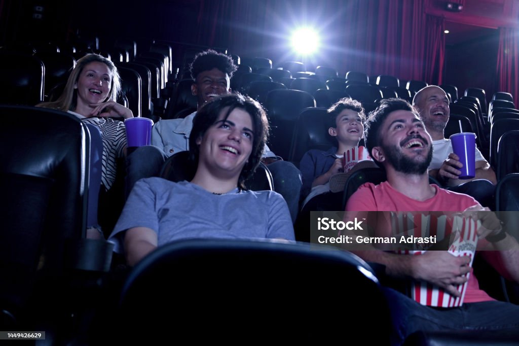 Friends watching a movie at the cinema Group of people eating popcorn having fun watching a movie in the cinema Movie Theater Stock Photo