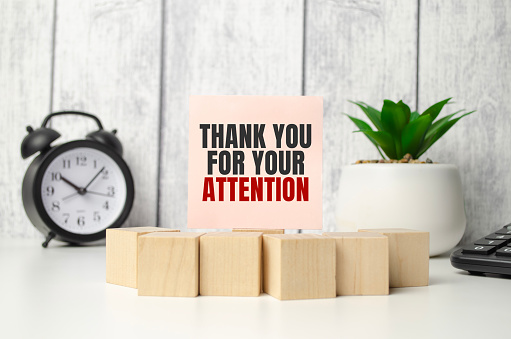 Thank Your For Your Attention on pink sticker with wooden block and alarm clock