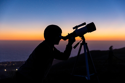 High quality stock photo of a boy stargazing with his mother after the sun sets.