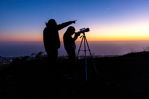 High quality stock photo of a boy stargazing with his mother after the sun sets.