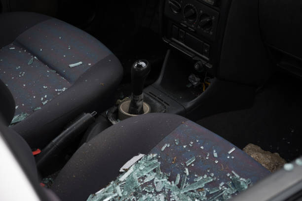 istock Broken glass on the front passenger seat. Car window broken with a stone. Vandalism on a car parked in the street. 1449439595