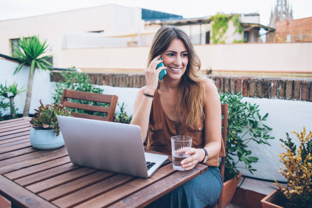 istock Smiling woman talking on phone on terrace 1449441059