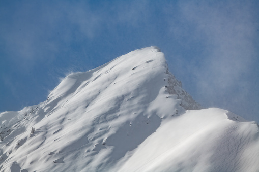 Snow capped, wind blown mountain peak near Cooke City, Montana, USA, North America.