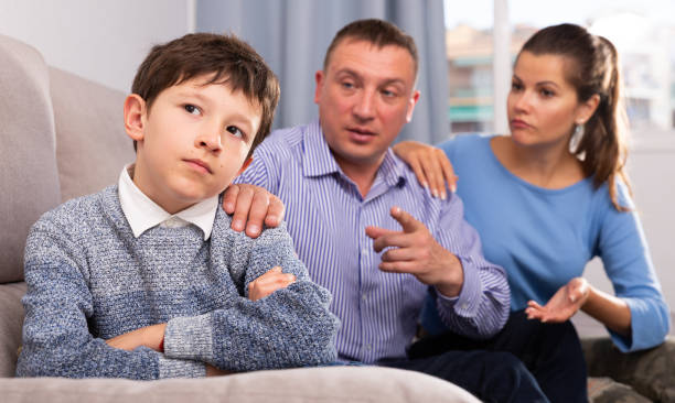 istock Frowning boy with mother and father berating him 1449458593