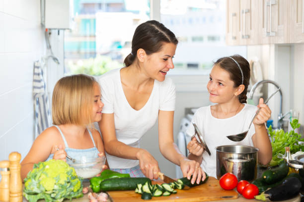 istock Young woman and two daughters cooking together 1449458633