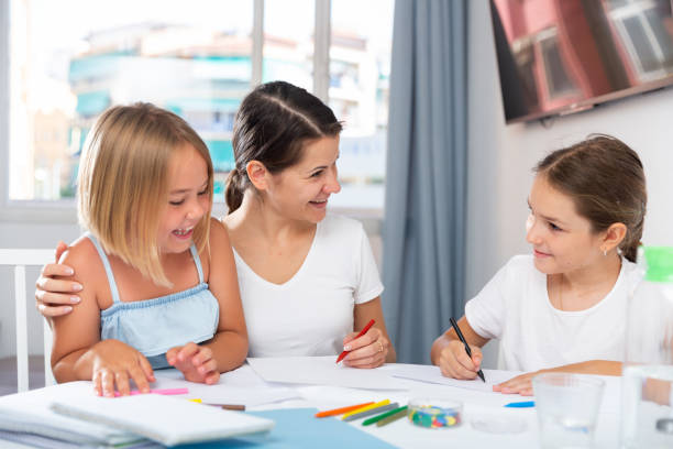 istock Young woman and two daughters drawing together 1449459161