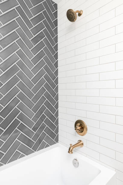 istock A shower with grey herringbone and white subway tiles. 1449461442