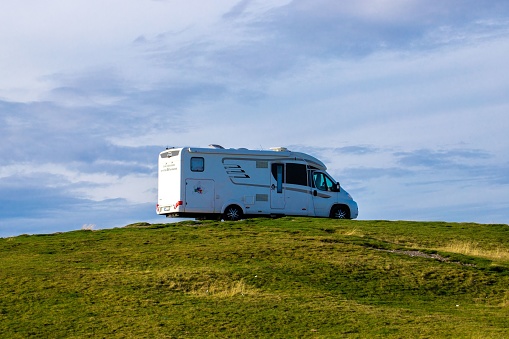 Ranca, Romania – September 14, 2022: A motorhome on the top of a hill under the blue cloudy sky