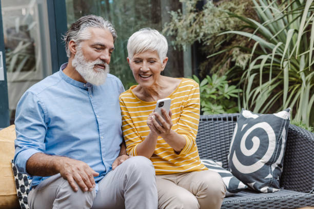 istock Happy senior couple relaxing and using smart phone on the balcony 1449466047