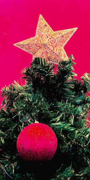 istock Artificial Christmas Tree in Front of Pink Wall 1449469882