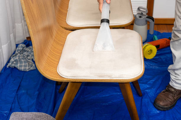 istock Man using a special vacuum to clean chair upholstery. 1449472316
