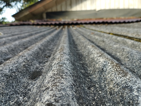 Close-up of asbestos roof showing texture and gray color and defocused background