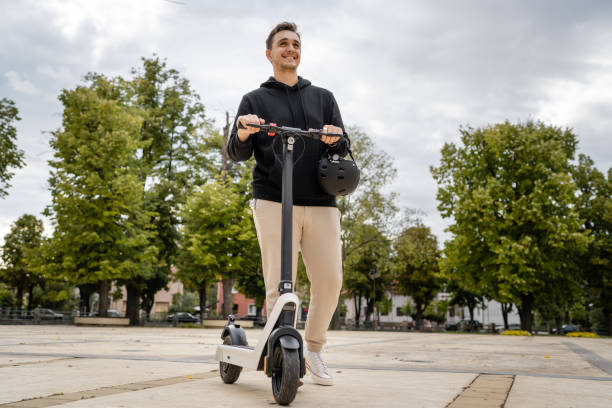 caucasian man drive or ride electric kick scooter e-scooter stock photo