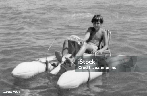 istock Image taken in the 60s: Smiling boy sitting in a pedal boat 1449477968