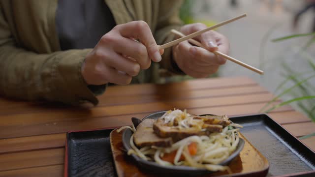 disposable chopsticks smoothed out over pork dish