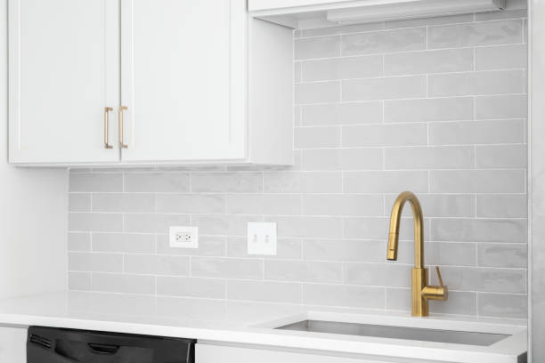 istock A gold faucet in a white kitchen with a subway tile backsplash. 1449479328