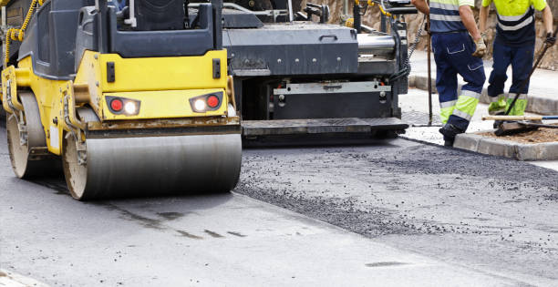 istock asphalt paving machines with circular roller and operators in uniform in the background 1449480231