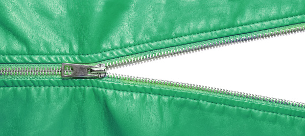 Green leather texture and open metal zipper isolated on white background. Business background, banner, header, mockup with copy space. Top view, flat lay. Sale, shopping, discount concept