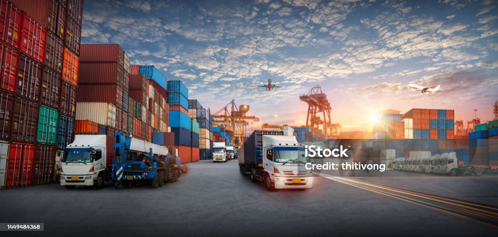 Logistics and transportation of Container Cargo ship and Cargo plane with working crane bridge in shipyard at sunrise, logistic import export and transport industry background Freight Transportation Stock Photo