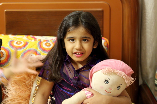 A little girl with her stuffed toy in her bedroom.