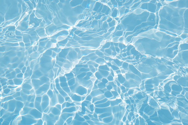 istock Defocus blurred transparent blue colored clear calm water surface texture with splashes and bubbles. Trendy abstract nature background. Water waves in sunlight with caustics. Blue water shinning 1449494345