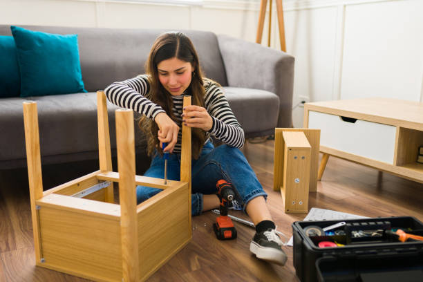 istock Attractive woman using tools to assembly furniture 1449497948