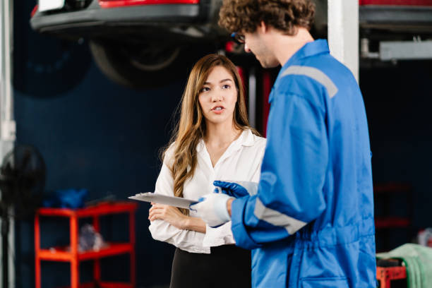 istock Car Mechanic hold the clipboard for checking list and repaired item while talking with customer at the repair garage 1449498789