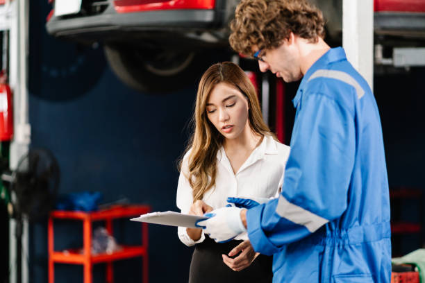 istock Car Mechanic hold the clipboard for checking list and repaired item while talking with customer at the repair garage 1449498931