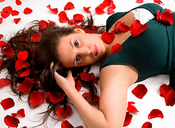 młoda kobieta, leżąc na płatek róży - human hair women horizontal rose petals zdjęcia i obrazy z banku zdjęć