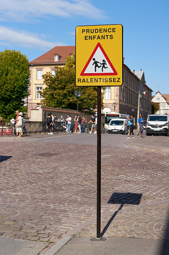Colmar, France – August 31, 2022: Sign in Colmar in France with the inscription Prudence Entfants Ralentissez. Translation: caution children, drive slowly