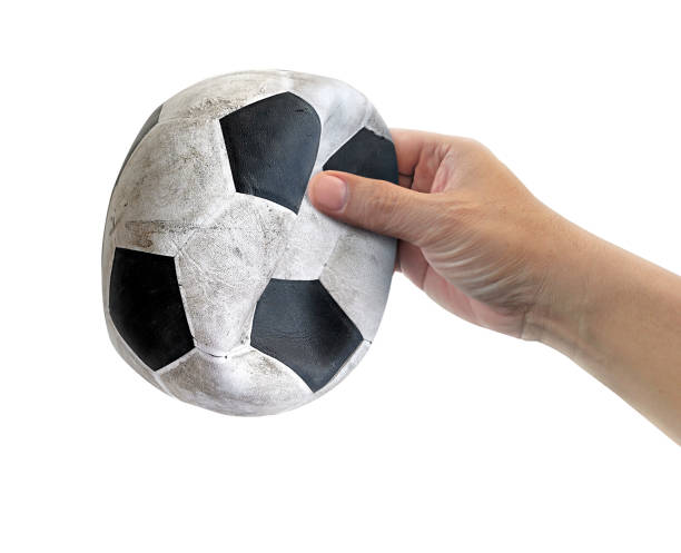 istock man hand with Old soccer ball on white background 1449511348