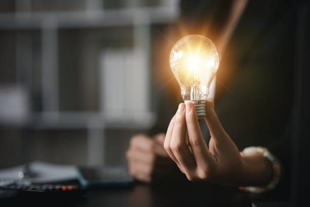 istock Person hold glowing light bulb, Creative new idea. Innovation, brainstorming, strategizing to make the business grow and be profitable. Concept execution, strategy planning and profit management 1449514313