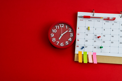 Calendar and clock on red background.