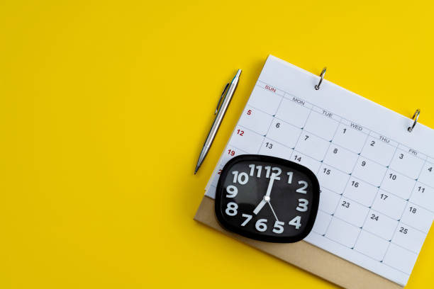 istock Calendar and alarm clock on yellow background 1449518638