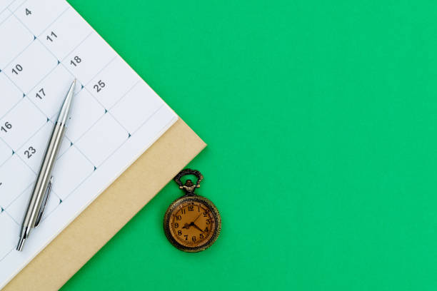 istock Calendar and pocket watch on green background 1449518741