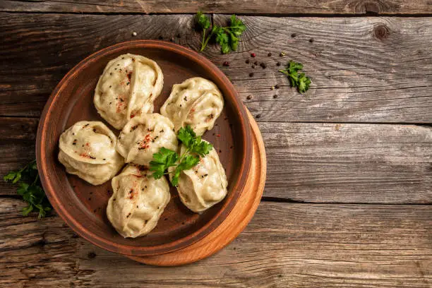 Photo of The National Kazakh and Uzbek cuisine. Manti or manty dumplings, popular asian dish. Food recipe background. space for text. top view