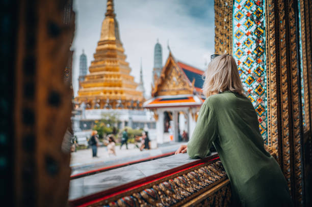 mujer joven explorando el gran palacio en bangkok - cultura tailandesa fotografías e imágenes de stock