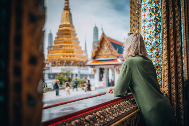 Young Woman Exploring The Grand Palace in Bangkok Young woman exploring Grand Palace and Wat Phra Kaew in Bangkok, Thailand buddhist house of worship stock pictures, royalty-free photos & images