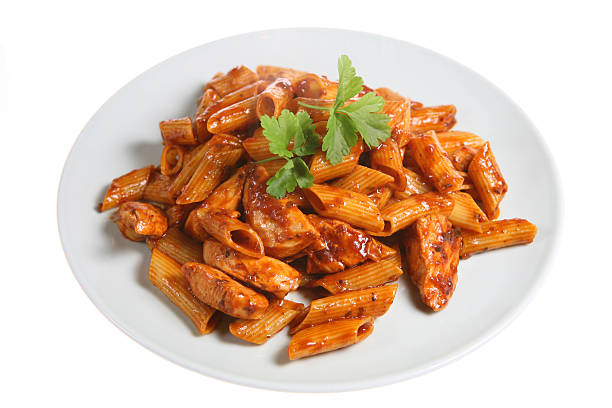 Pasta Dinner Penne pasta with chicken pieces in a sun-dried tomato and olive sauce chicken rigatoni stock pictures, royalty-free photos & images