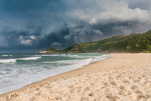 Scenic beach with sunset light before an oncoming storm. Mole beach in Florianopolis