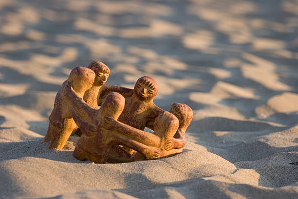 Latin American sculpture (generic - no copyright) in the sand along seashore.  Late afternoon sun.