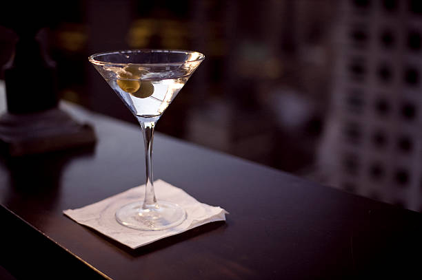 Glass of martini on a white napkin sipping a martini in mid Manhattan martini stock pictures, royalty-free photos & images